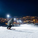 Palandöken’de gece kayağı yapan bir sporcu ve ışıklandırılmış kayak pistleri